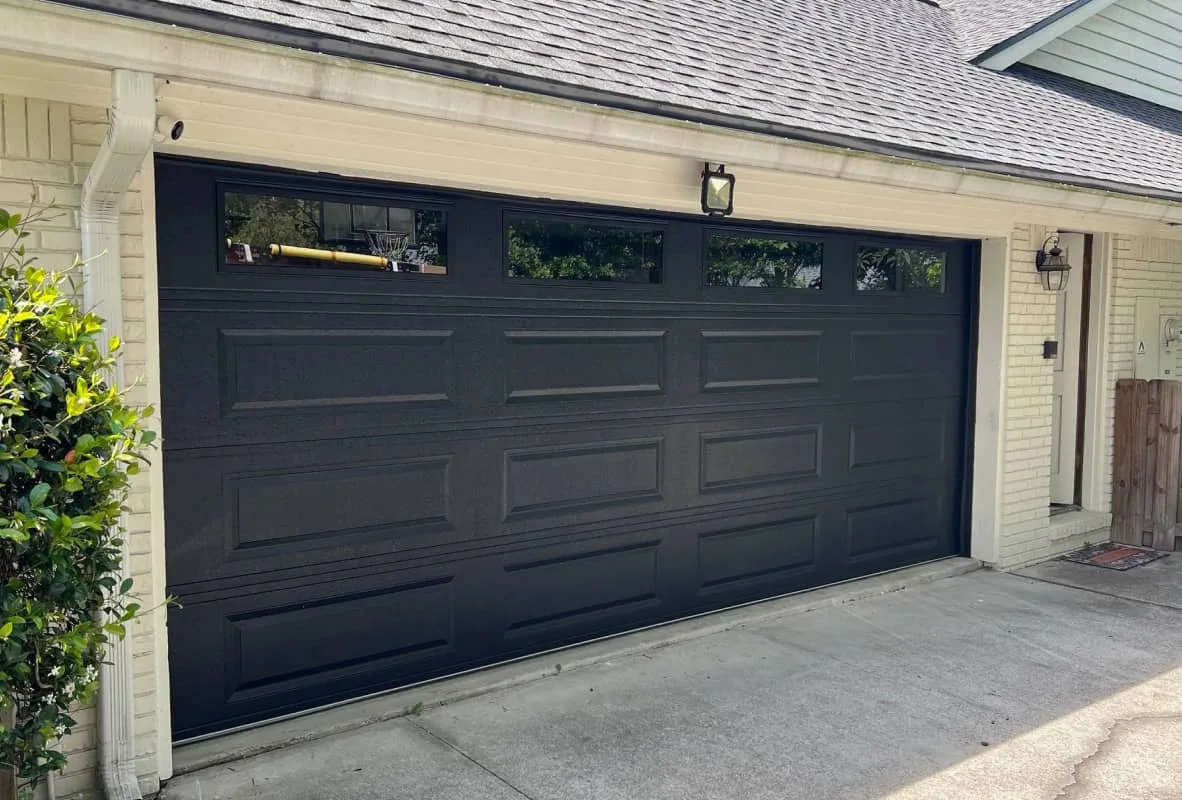 Black long raised panel garage door with windows